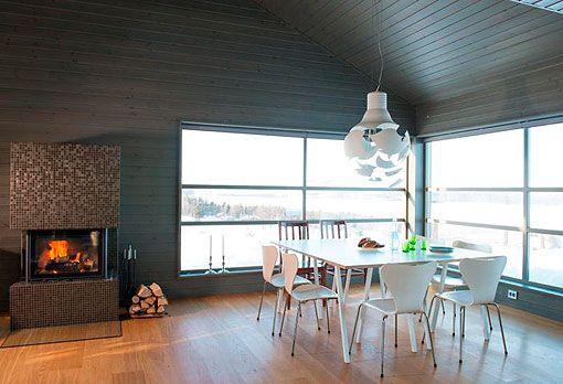 Comedor con vistas a las montañas nevadas Casa de madera en medio de la nieve. Comedor con muebles blancos