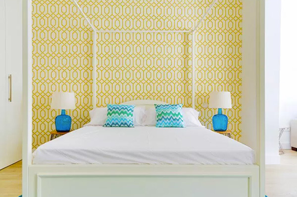 Un dormitorio con papel pintado amarillo en la pared