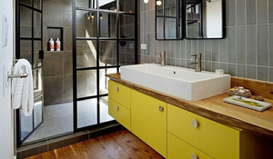 Baño de estilo industrial con mueble de lavabo amarillo