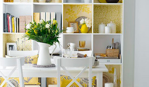 Estantería con la trasera forrada de papeles pintados en amarillo