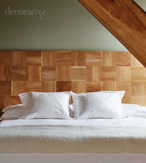 Dormitorio abuhardillado con cabecero de madera