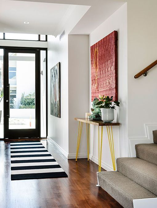 entrada con una consola vintage de una casa relajada y luminosa