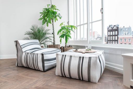 Fibras y materiales naturales: sillón y puf de loneta, y plantas en cestos