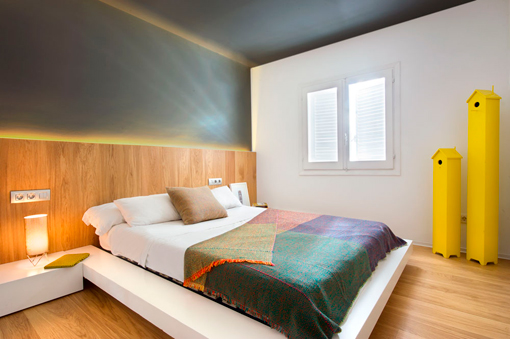 Reforma Integral: dormitorio con pared acristalada con perfiles metálicos