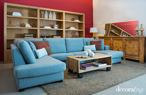 Salón con paredes rojas y sofá azul