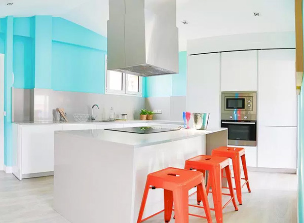 Una cocina blanca con toques de color