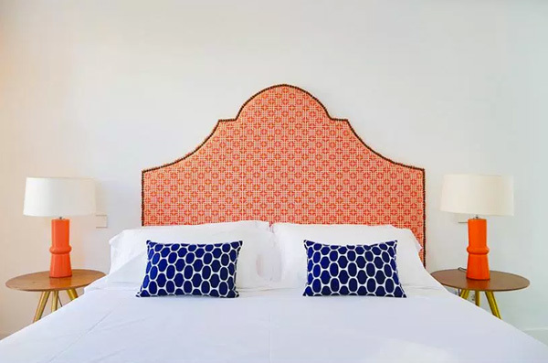 Dormitorio con cabecero tapizado en naranja