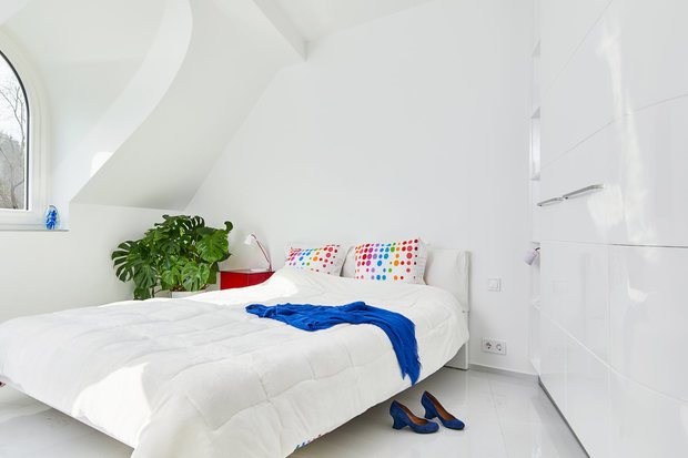 Dormitorio blanco con pinceladas de contraste en rojo y azul