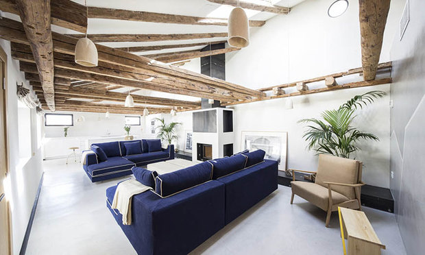 Ático reformado en Madrid: salón con chimenea y sofás azules