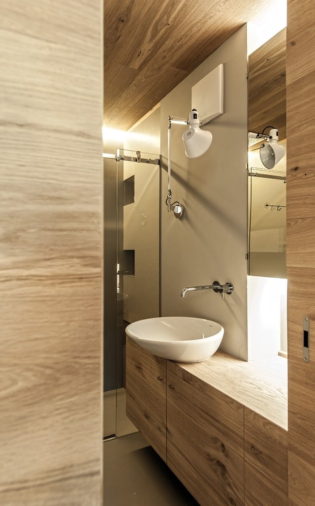 Baño moderno con lavamanos sobre mueble de madera