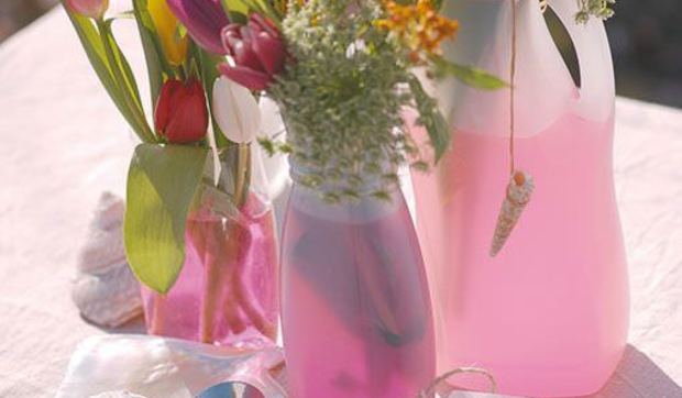 Envases convertidos en floreros para decorar las mesas de exterior