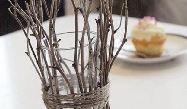 Un candelero navideño con ramas secas y velitas de té